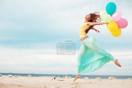 Happy girl with bunch of colorful air balloons