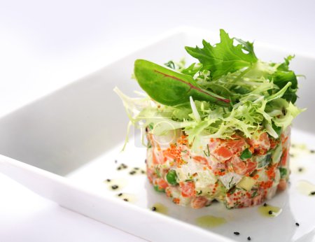 Salad with salmon, caviar and arugula on a white background
