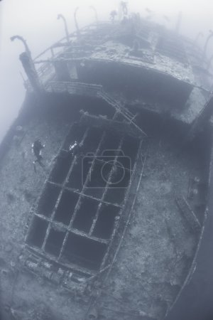 Divers on a deep underwater shipwreck