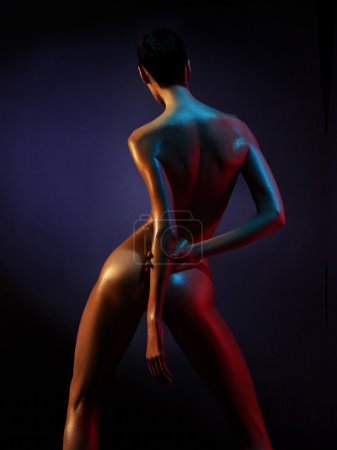 Elegant nude model in the light colored spotlights