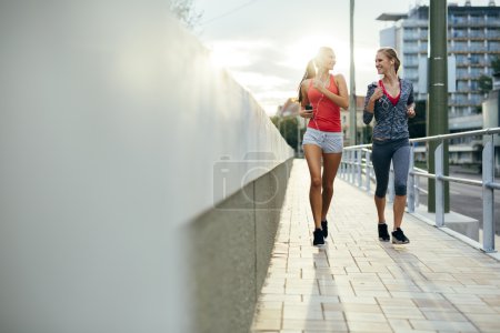 Women jogging in city in dusk