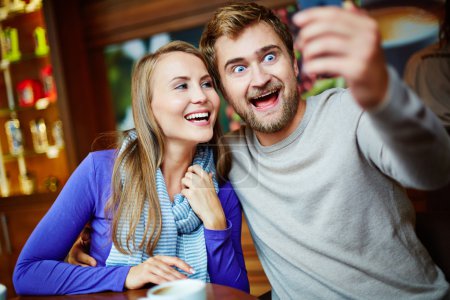 Couple taking selfie in cafe