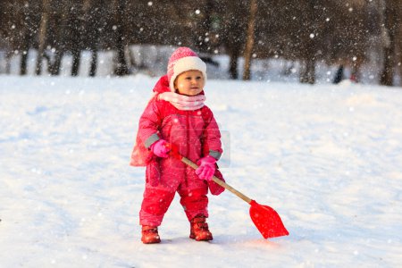 cute little toddler girl  dig in winter snow