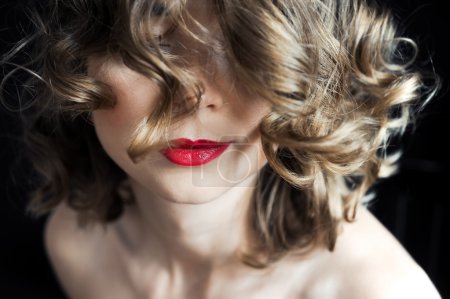 portrait of a young curly girl with dark red lips