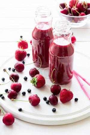 Two bottle of fresh strawberry blueberry smoothies. Selective focus
