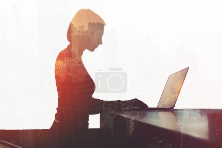Young businesswoman is keyboarding on net-book at office desktop