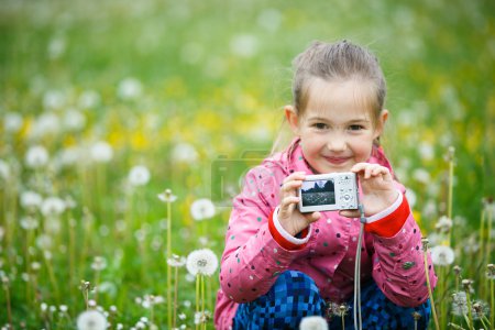 Little smiling girl proudly showing her photograph