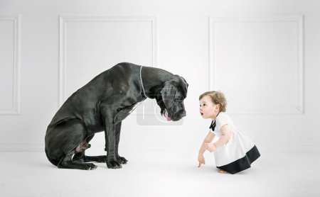 Little girl posing against a big dog