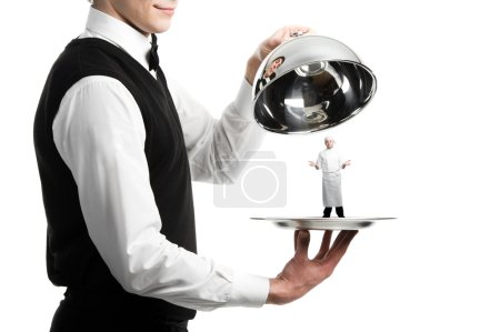 Hands of waiter with cloche and chef