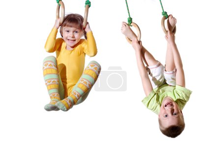 little children are doing exercises with gymnastic rings 