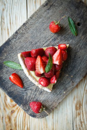 piece of tart with custard and strawberries