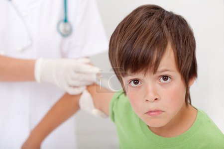 Sad boy receiving injection