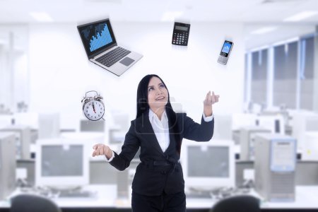 Multitasker businesswoman using laptop, calculator, phone, clock