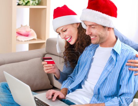 Young couple with laptop and credit card buying online
