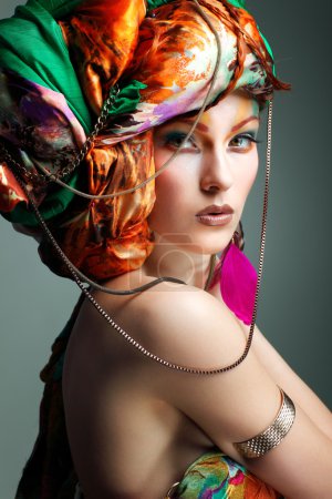 A photo of beautiful redheaded girl in a head-dress from the coloured fabric, glamour