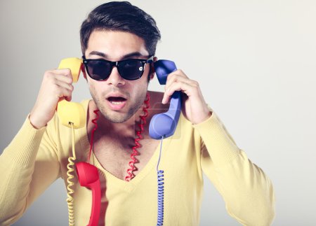 funny call center guy with hipster glasses and colouful phones