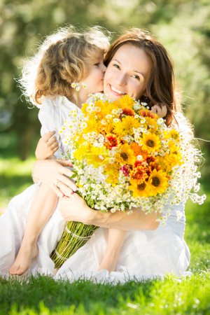 Woman and child holding bouquet of flowers