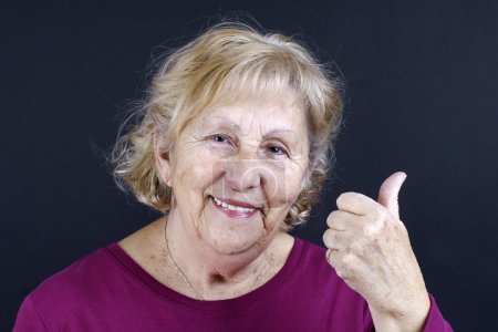 Senior woman holding thumbs up