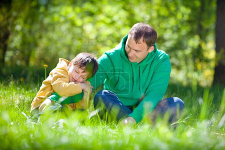 Cute little boy hugs his father outdoors
