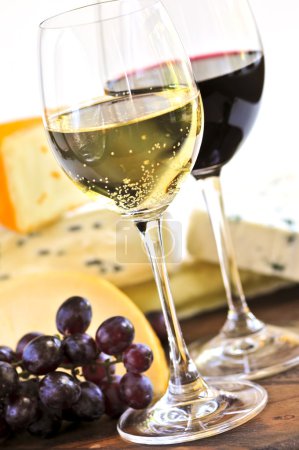 Wineglasses with red and white wine and assorted cheeses