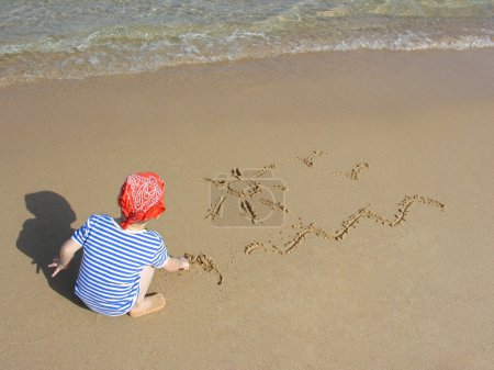 Boy draw on beach