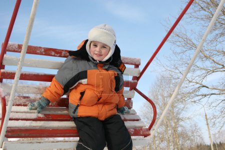 Boy on winter seesaw