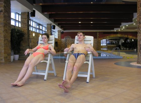 Couple on chairs and swimming pool