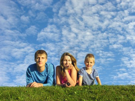 Family on herb under blue sky