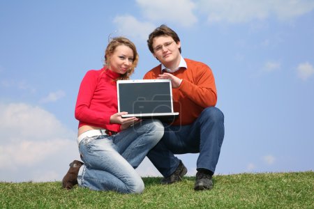 Couple with notebook on meadow