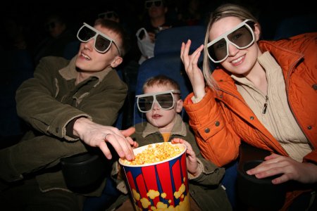 Family in stereo cinema. focus on popcorn