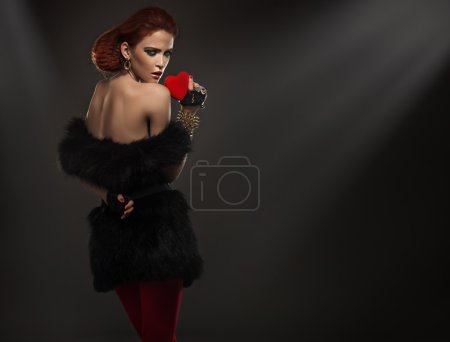 Beauty lady in fur holding red heart