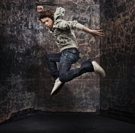 Young hip-hop dancer over a grunge wall