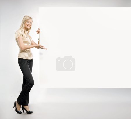 Beautiful blonde secretary showing an empty board,lots of copyspace