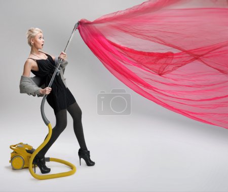 Young woman using vacuum cleaner. Isolated.