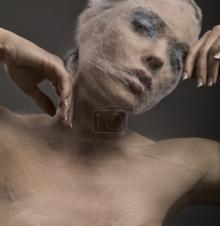 Fine art portrait of a young woman wraped with cowebs