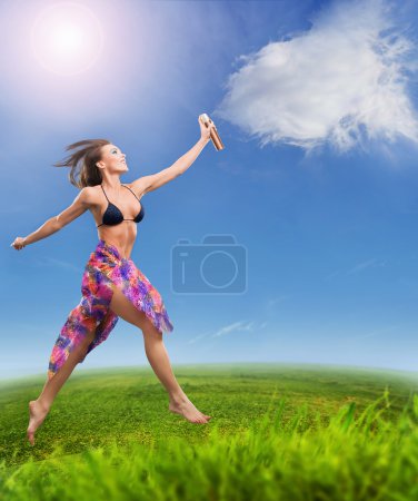 Young beautiful woman sprays clouds on a sunny day