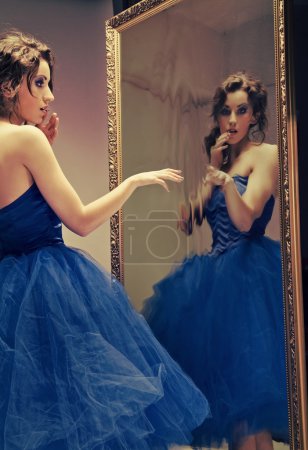 Pretty brunette doing make up looking at the mirror - vintage look