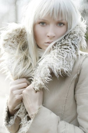 Portrait of a beautiful girl wearing white fur