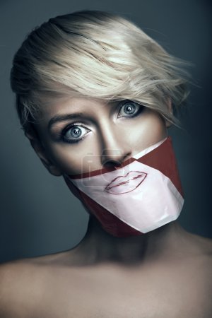 Conceptual photo of woman with the mouth taped up