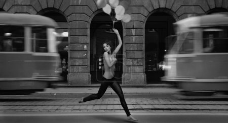 Fine art photo- young woman holding balloons in a empty city street