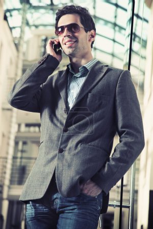 Cheerful businessman chatting over cellphone
