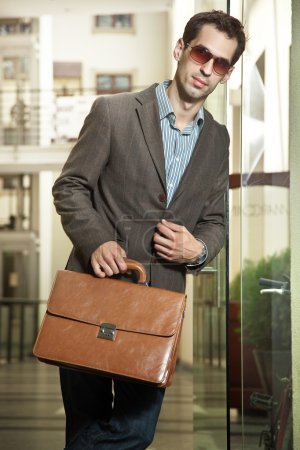 Confident young businessman holding a briefcase