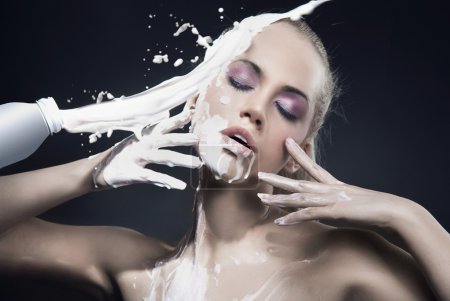 Portrait of a beautiful blonde dousing with cream