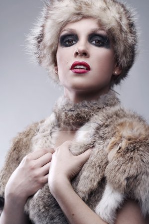 Beautiful young blond woman in fur, studio shot