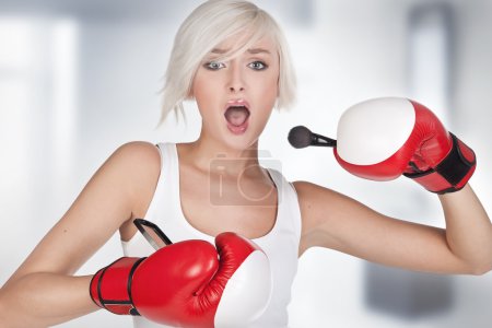 Young beauty doing make up in boxing gloves