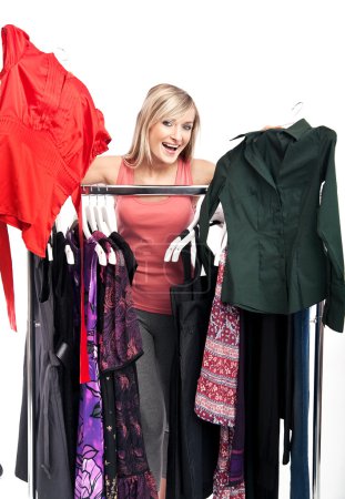Young happy woman has a plenty of clothes to choose from
