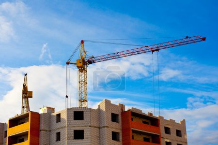 Two cranes and house construction