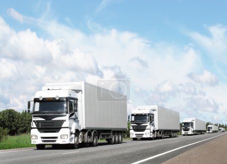 Caravan of white trucks on highway
