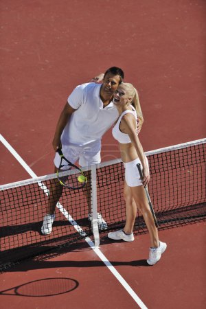 Happy young couple play tennis game outdoor