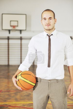 Businessman holding basketball ball